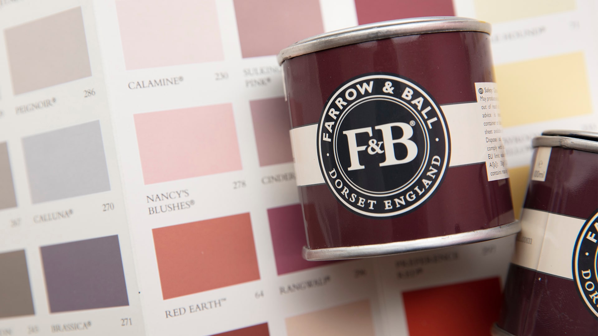 a colour card featuring farrow and ball bedroom colours and a couple of paint tins